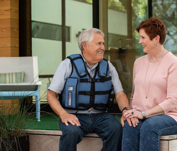 photo of mature couple sitting on steps with the man wearing AffloVest